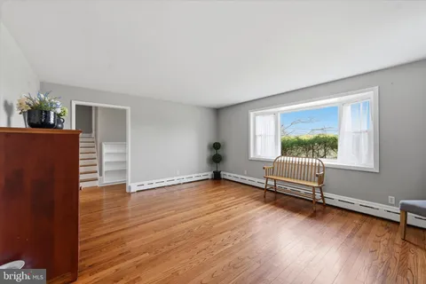 a view of a livingroom with wooden floor and a ceiling fan
