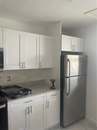 a kitchen with a refrigerator sink stove and cabinets