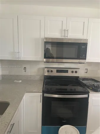 a kitchen with appliances a sink and cabinets