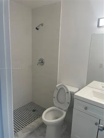 a bathroom with a granite countertop toilet and a sink