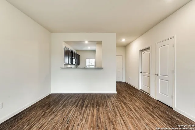 a view of a room with wooden floor and white doors