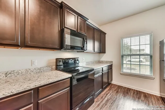 a kitchen with granite countertop cabinets stainless steel appliances and a sink