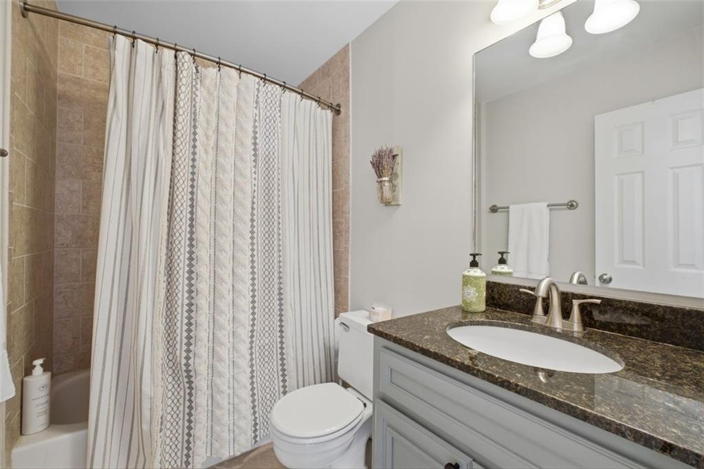 1468 Briarwood Road Northeast, Unit 901 Atlanta, GA 30319 - Photo 21 of 27 a bathroom with a granite countertop sink and a mirror with toilet