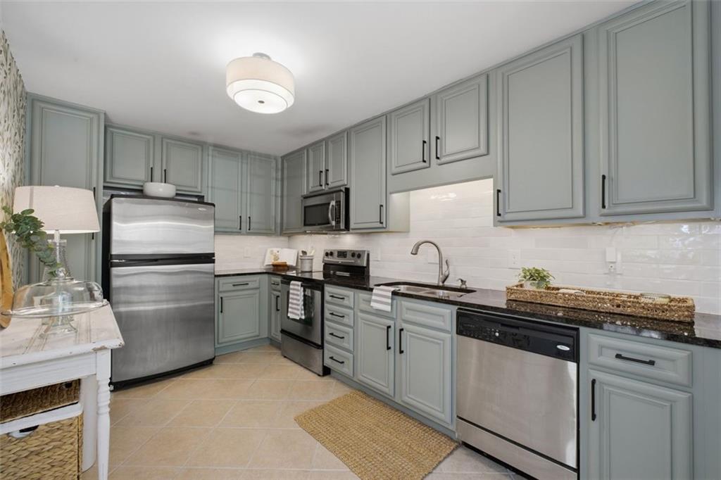 1468 Briarwood Road Northeast, Unit 901 Atlanta, GA 30319 - Photo 8 of 27 a kitchen with a sink white cabinets and stainless steel appliances