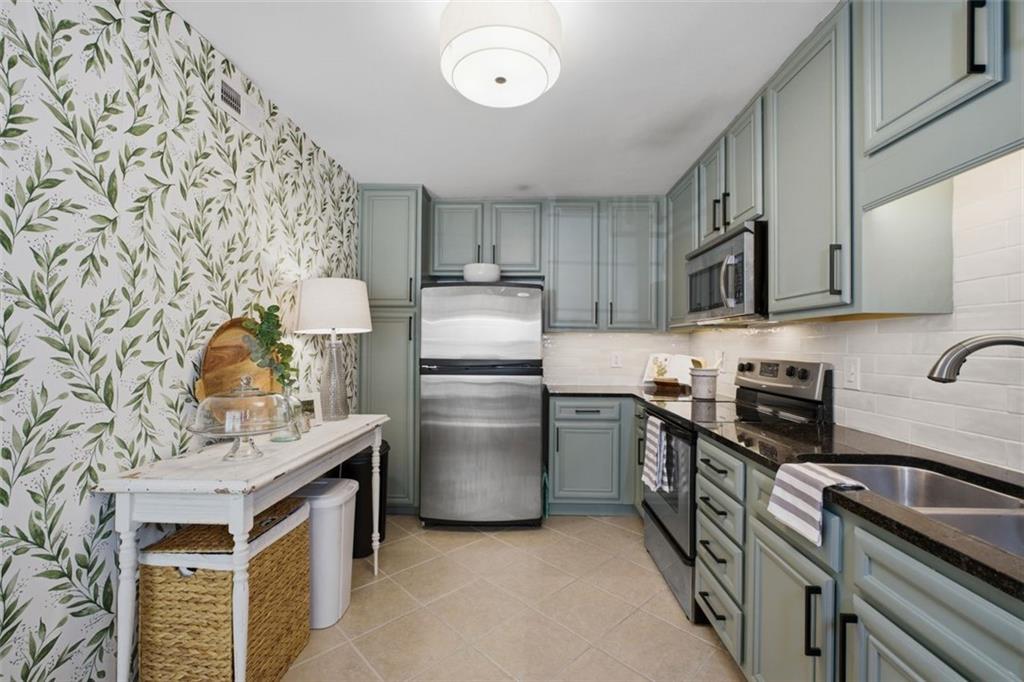 1468 Briarwood Road Northeast, Unit 901 Atlanta, GA 30319 - Photo 10 of 27 a kitchen with stainless steel appliances granite countertop a stove a sink dishwasher and a refrigerator