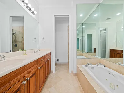 a bathroom with a double vanity sink mirror double and bathtub