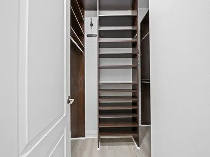 a view of walk in closet with empty racks