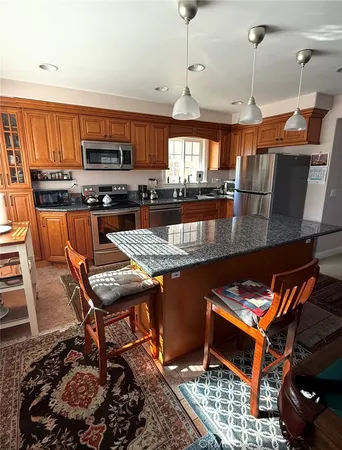a kitchen with stainless steel appliances granite countertop a stove a sink and a refrigerator