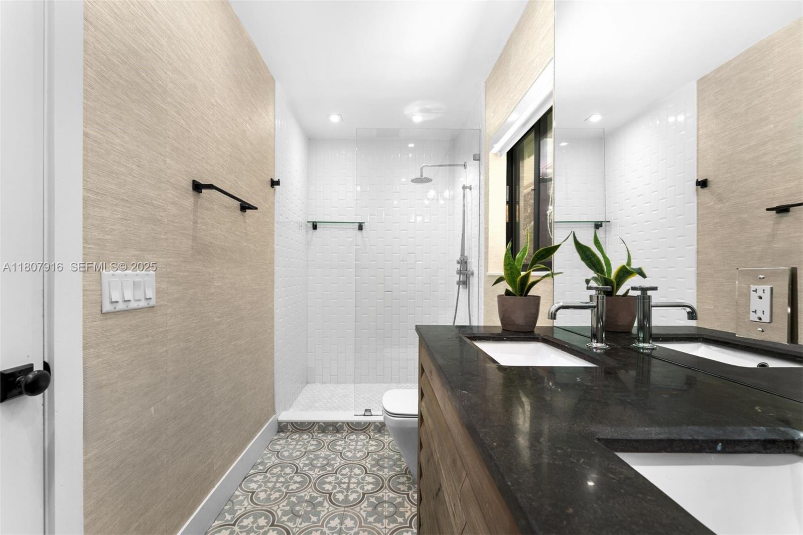 4250 Bay Point Road Miami, FL 33137 - Photo 16 of 43 a bathroom with a sink a mirror and a shower