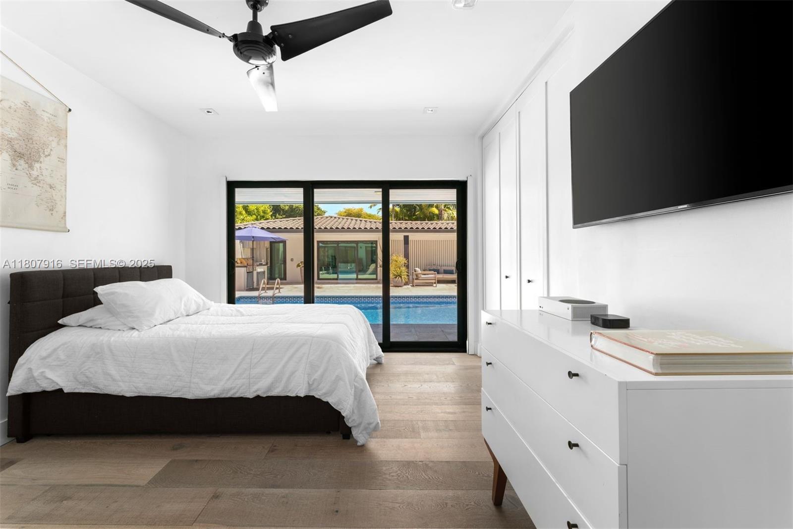 4250 Bay Point Road Miami, FL 33137 - Photo 18 of 43 a bedroom with a large bed and a flat tv screen on dresser