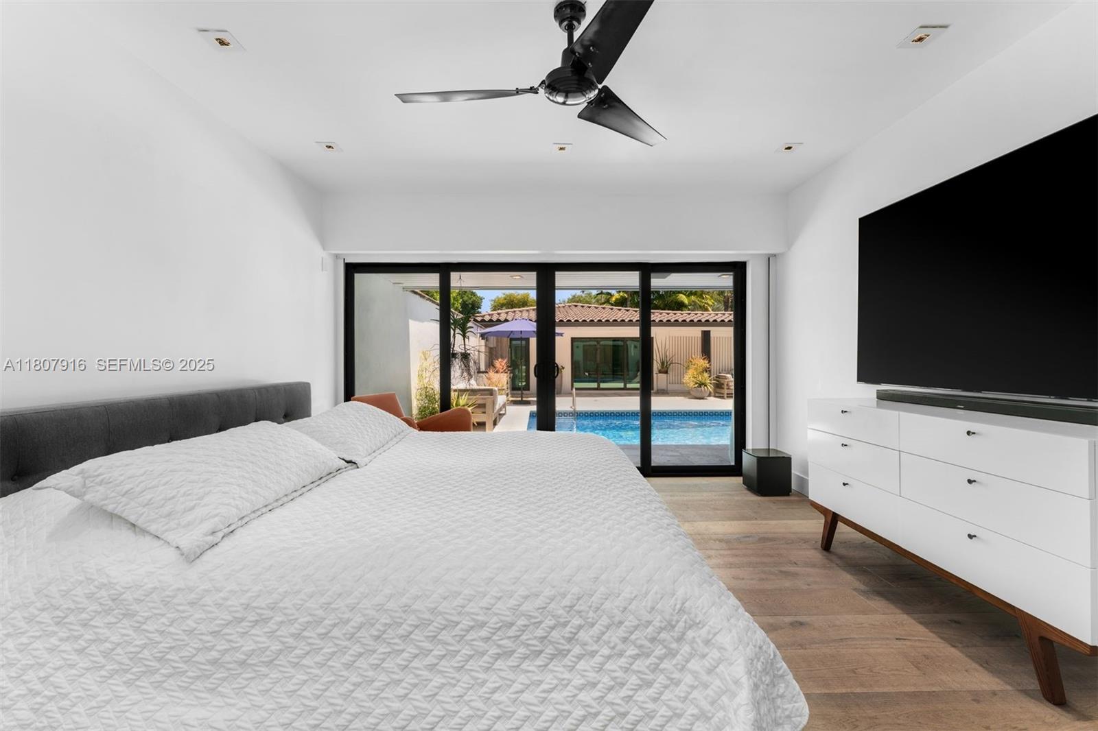 4250 Bay Point Road Miami, FL 33137 - Photo 20 of 43 a bedroom with a bed and a flat tv screen on dresser