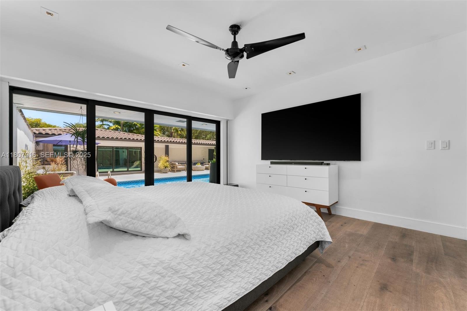 4250 Bay Point Road Miami, FL 33137 - Photo 21 of 43 a bedroom with a bed tv and a large window