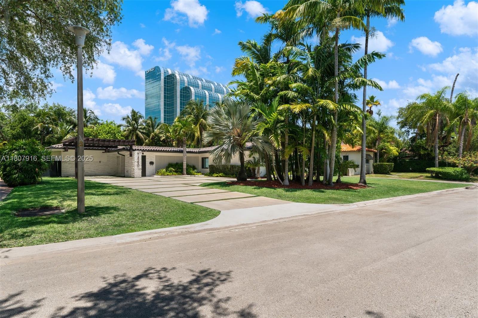 4250 Bay Point Road Miami, FL 33137 - Photo 3 of 43 a view of a house with a yard and palm trees