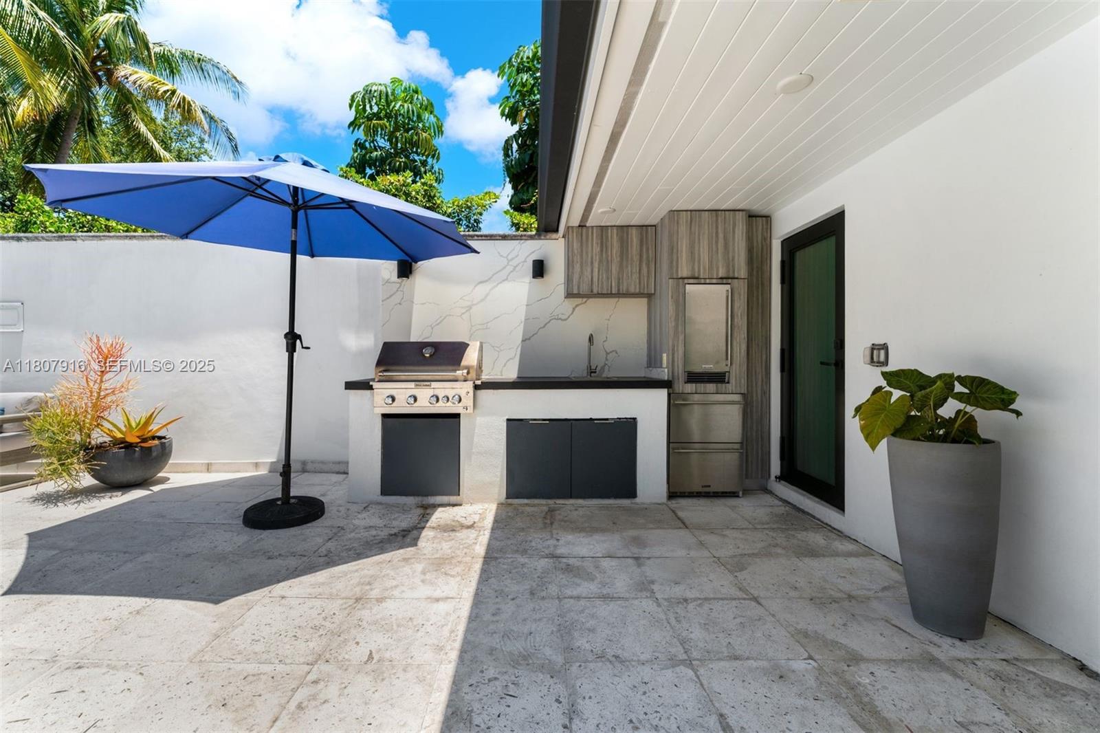 4250 Bay Point Road Miami, FL 33137 - Photo 38 of 43 a kitchen with stainless steel appliances kitchen island granite countertop a refrigerator and a sink