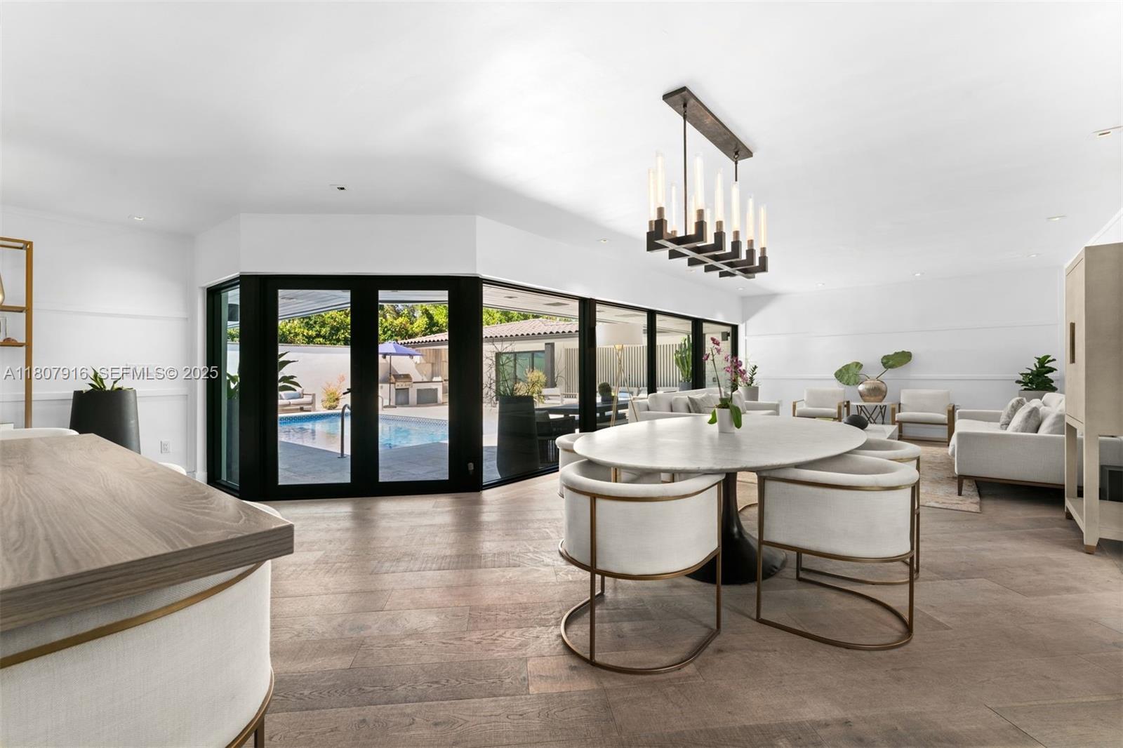 4250 Bay Point Road Miami, FL 33137 - Photo 10 of 43 a living room with furniture a chandelier and a dining table