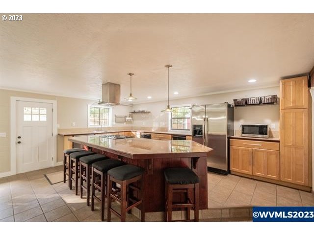 6057 Treehouse Road Monmouth, OR 97361 - Photo 16 of 32 a kitchen with stainless steel appliances kitchen island granite countertop a table chairs and a refrigerator