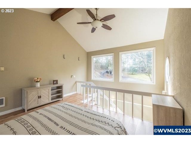 6057 Treehouse Road Monmouth, OR 97361 - Photo 17 of 32 a view of a bedroom with furniture a ceiling fan and wooden floor