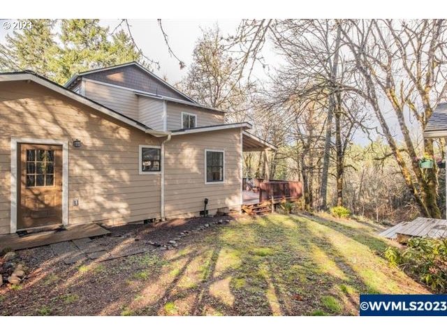 6057 Treehouse Road Monmouth, OR 97361 - Photo 21 of 32 a backyard of a house with table and chairs and wooden fence