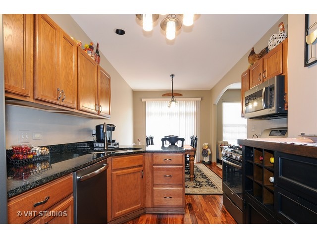503 Goodwin Drive, Unit 503 Bolingbrook, IL 60440 - Photo 2 of 10 a kitchen with stainless steel appliances granite countertop a sink a stove cabinets and wooden floor