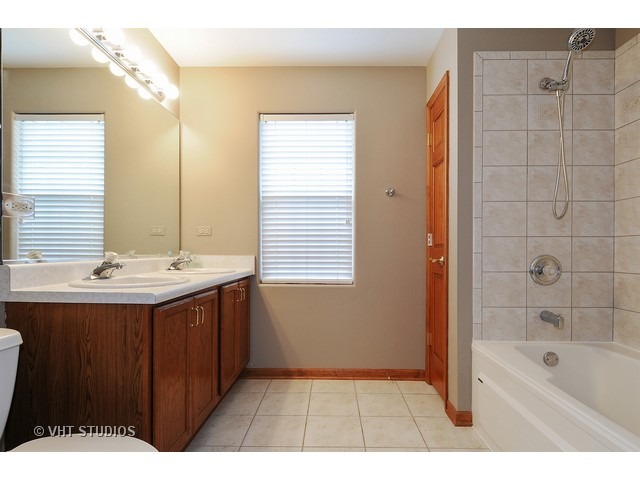 503 Goodwin Drive, Unit 503 Bolingbrook, IL 60440 - Photo 7 of 10 a bathroom with a sink a mirror and a bathtub