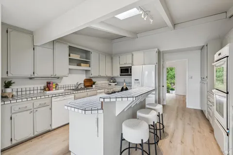 a kitchen with stainless steel appliances granite countertop a white cabinets and wooden floor