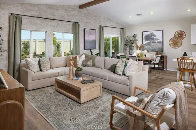 a living room with furniture wooden floor and a large window
