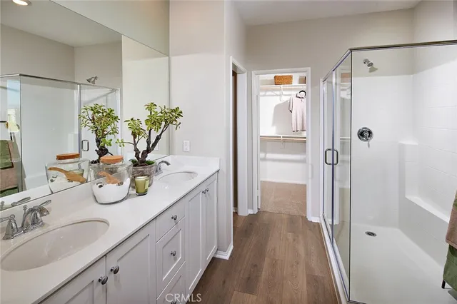 a bathroom with a granite countertop shower a sink and a mirror