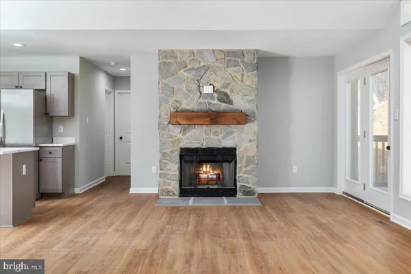 a living room with a fireplace and wooden floor
