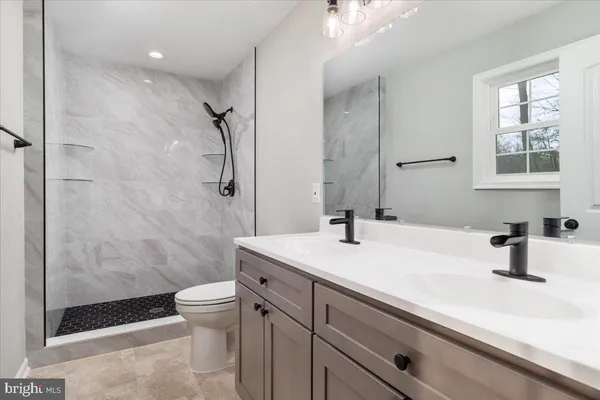 a bathroom with a sink a toilet and shower