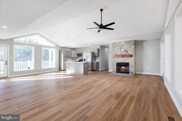 a view of empty room with wooden floor and fireplace