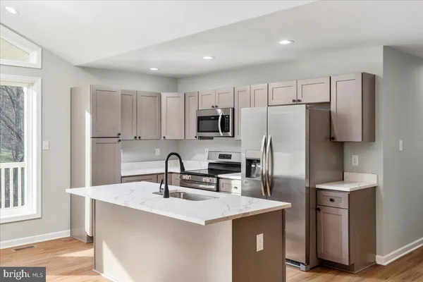 a kitchen with stainless steel appliances a sink stove refrigerator and cabinets