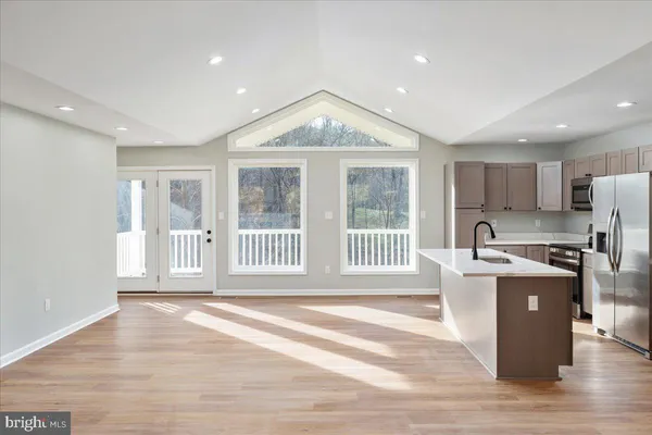 a kitchen with stainless steel appliances granite countertop a stove a sink and a refrigerator