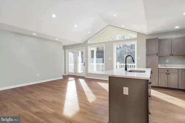 a large kitchen with stainless steel appliances granite countertop a sink and cabinets with wooden floor