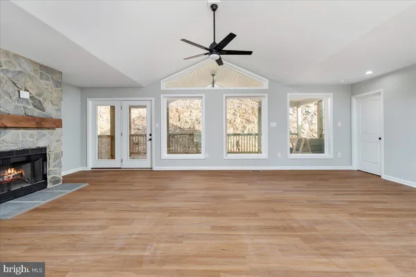 a view of an empty room with window and fireplace