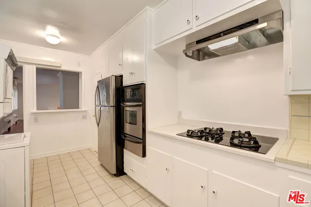 a kitchen with a refrigerator and a stove top oven