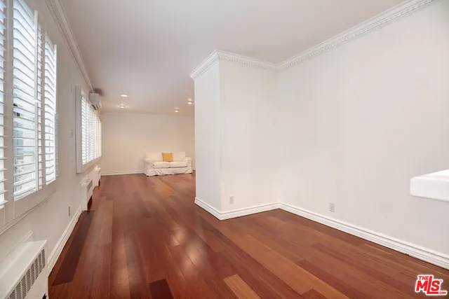 a view of a room with wooden floor and a window