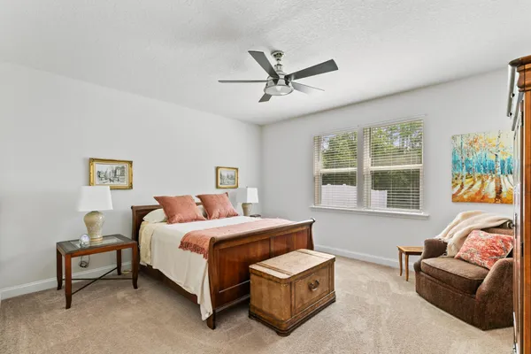 a bedroom with a bed and a couch next to a window