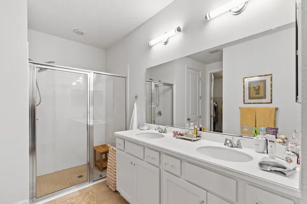 a bathroom with a double vanity sink mirror double and shower