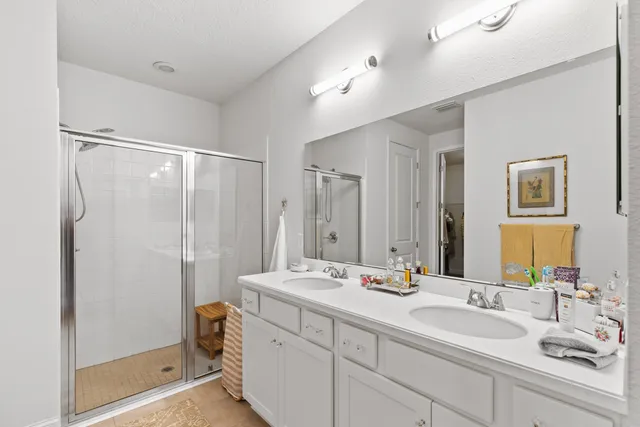 a bathroom with a double vanity sink mirror double and shower