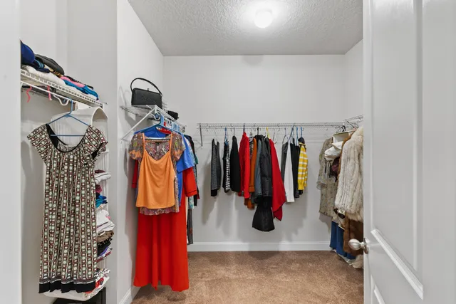 a view of walk in closet with clothes