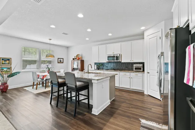 a kitchen with white cabinets and stainless steel appliances