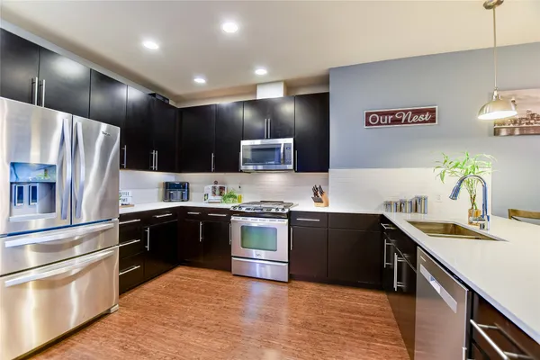 a kitchen with stainless steel appliances granite countertop a sink a stove and refrigerator