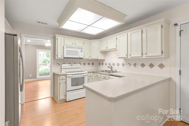a view of a kitchen with stainless steel appliances cabinets a island and a window
