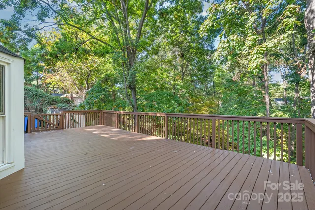 a view of a house with an empty space and wooden deck