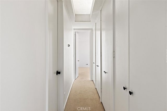 a view of a hallway with wooden floor and closet
