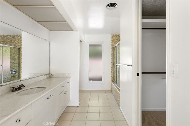 a bathroom with a granite countertop sink mirror and a bathtub