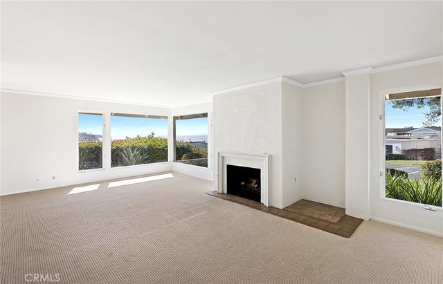 a view of an empty room with a fireplace and a window
