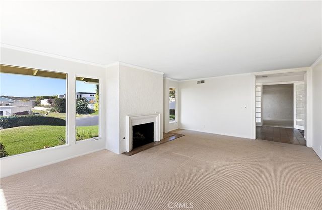 a view of an empty room with a fireplace and a window