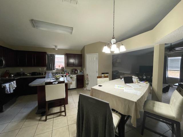 204 Limestone Circle Crestview, FL 32539 - Photo 7 of 19 a view of a dining room and livingroom with furniture wooden floor a rug a fireplace and a chandelier