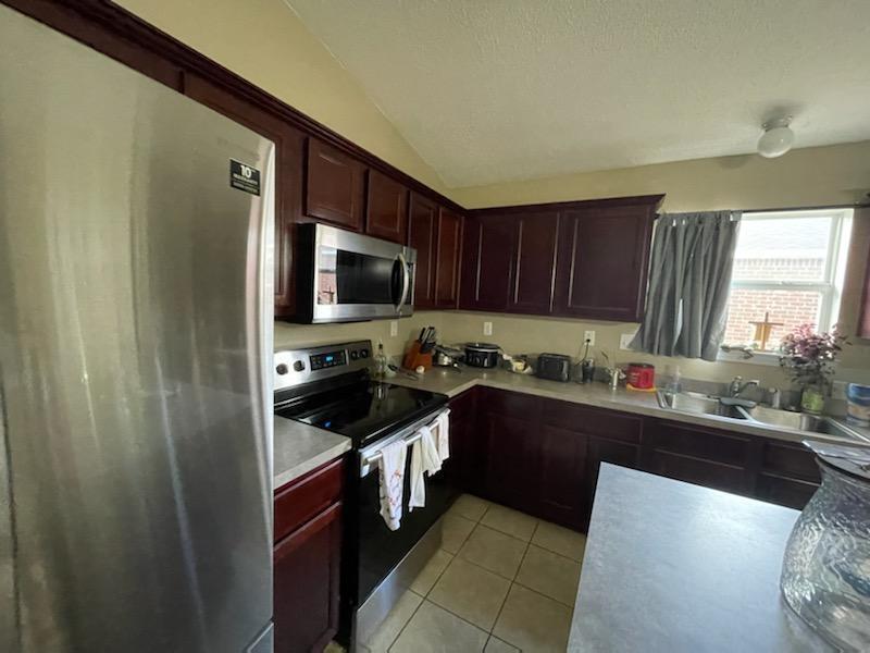 204 Limestone Circle Crestview, FL 32539 - Photo 9 of 19 a kitchen with a sink a stove top oven a refrigerator cabinets and a window